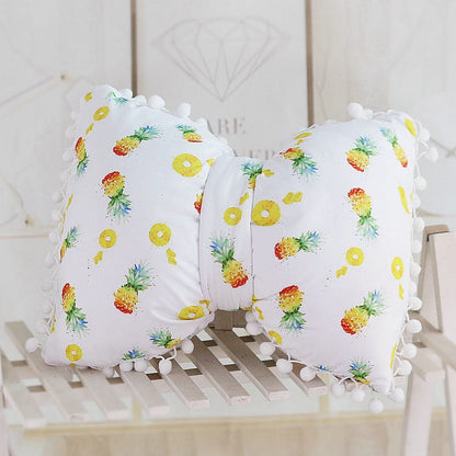 White bow decorative pillows with pineapple and cactus print and pom pom trim, set of two