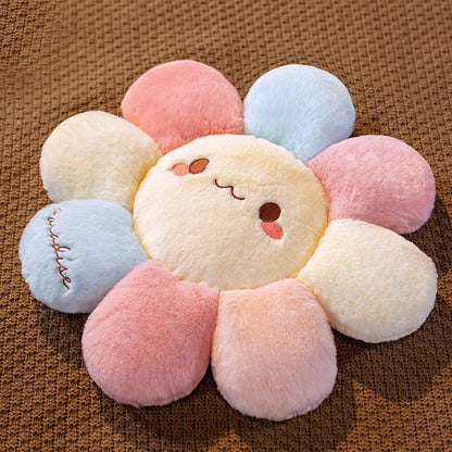 Soft plush flower pillow with embroidered smile and pastel petal segments