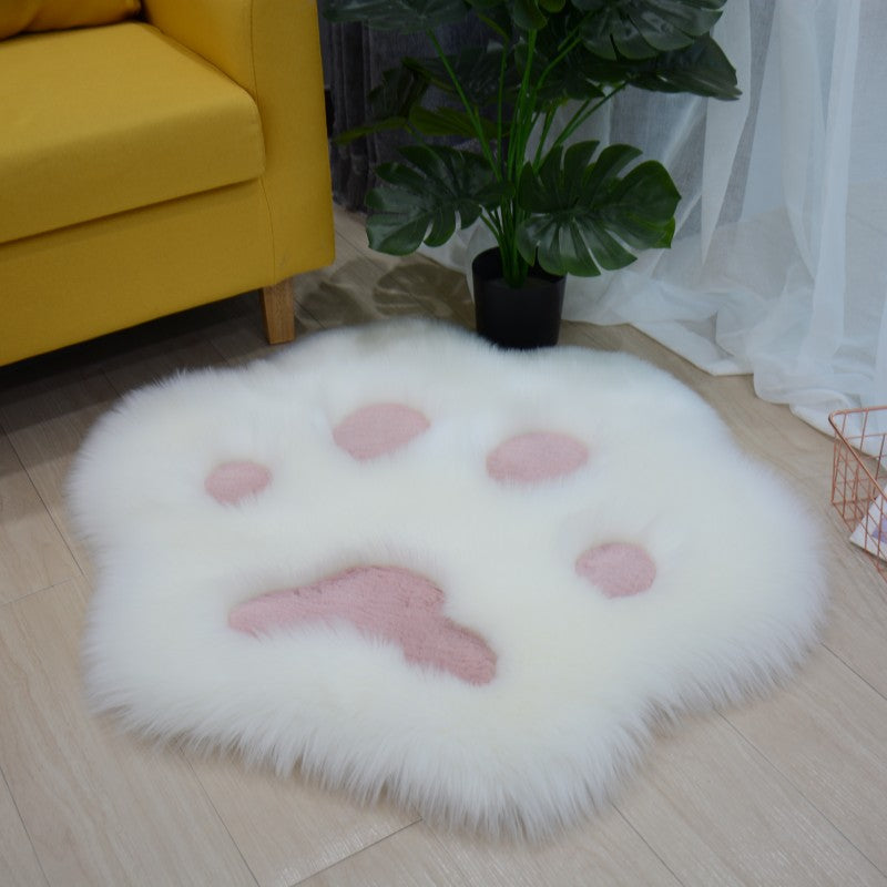 White faux fur round cat paw rug with light pink pad details and raised plush texture