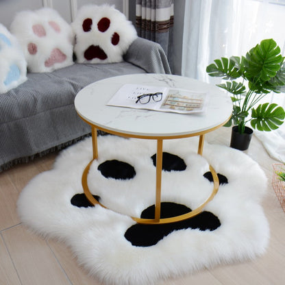 White faux fur cat paw area rug with black paw prints and rounded edge pads