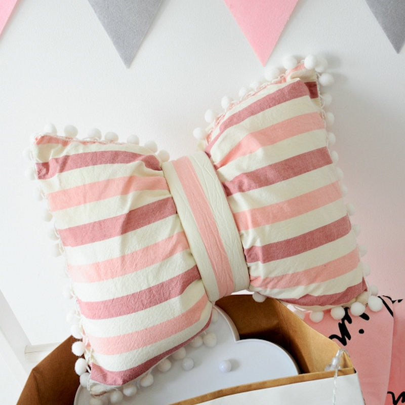Pink and cream striped bow decorative pillows with pom pom trim, set of two
