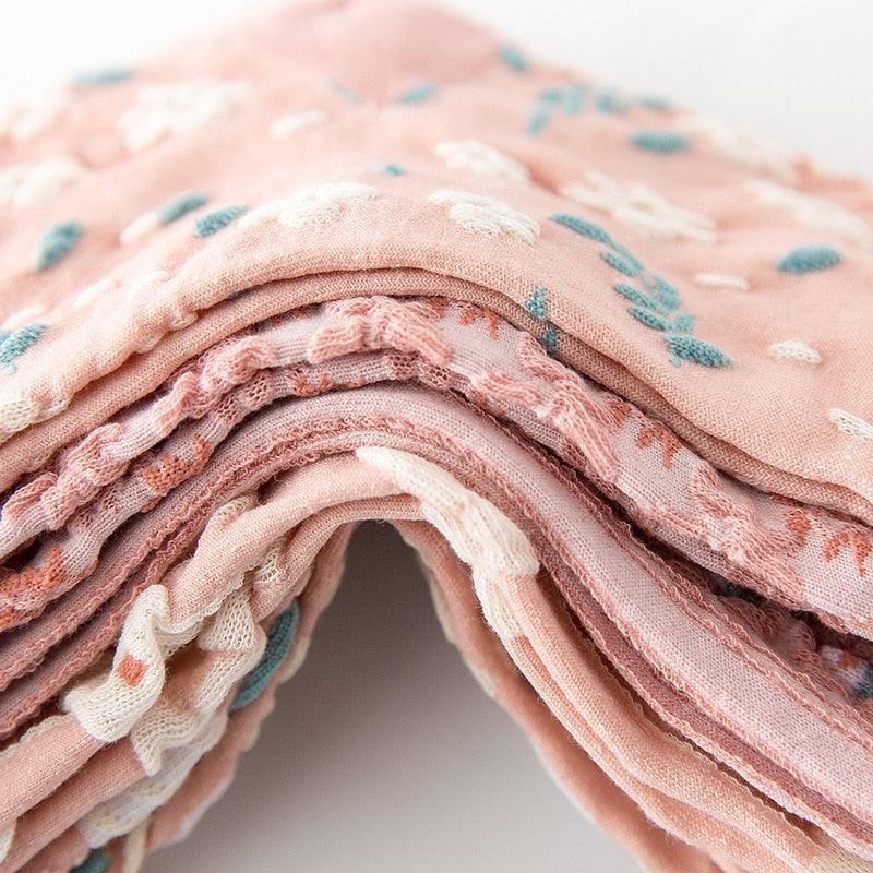 Rolled floral embroidered sock fabric in light pink with layered lace-like stitching