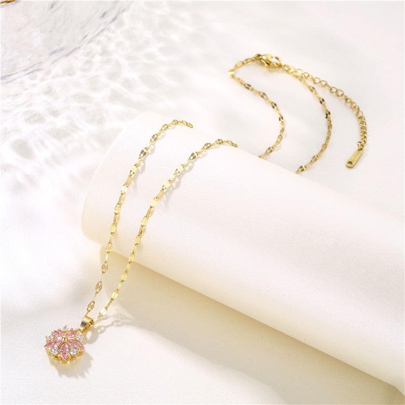 Floral pendant necklace with pink cherry blossom charm on gold-tone link chain