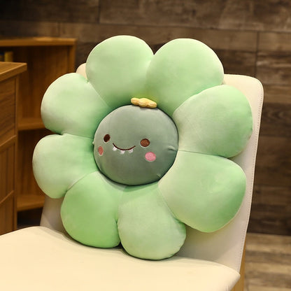 Plush flower pillow with green petals and a smiling animal face in the center