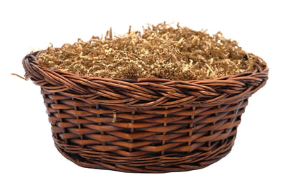 Brown wicker basket lined with shredded filler for gift presentation