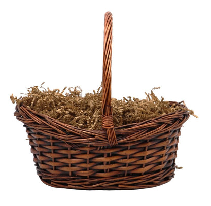 Wicker gift basket with handle, filled with tan shredded filler