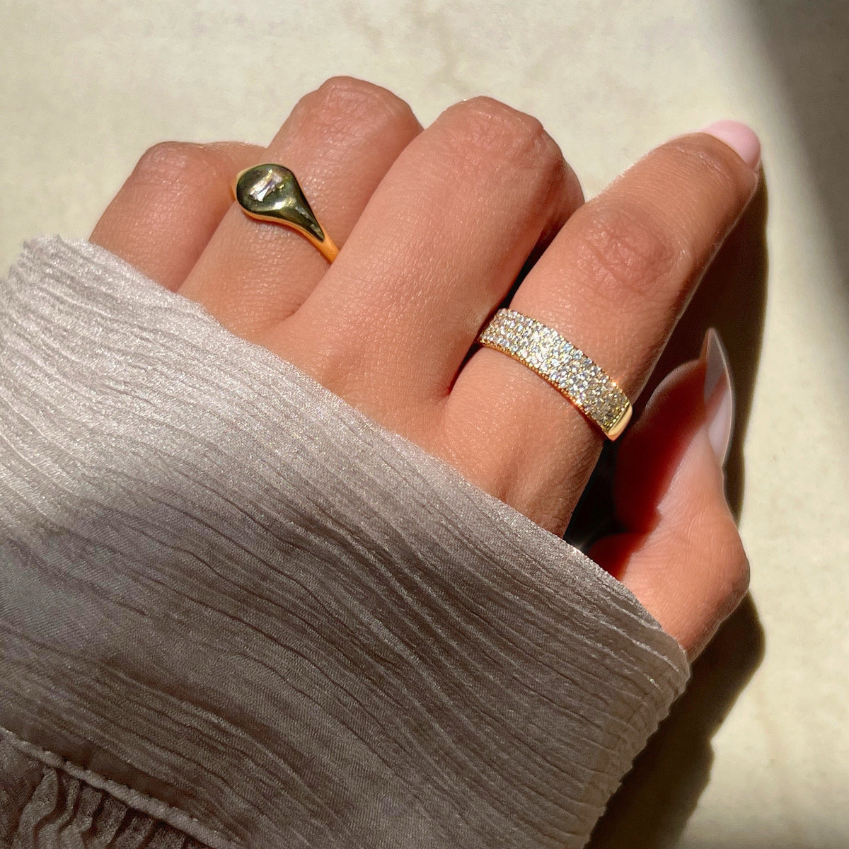 Gold-tone signet ring with dark green oval stone and smooth bezel
