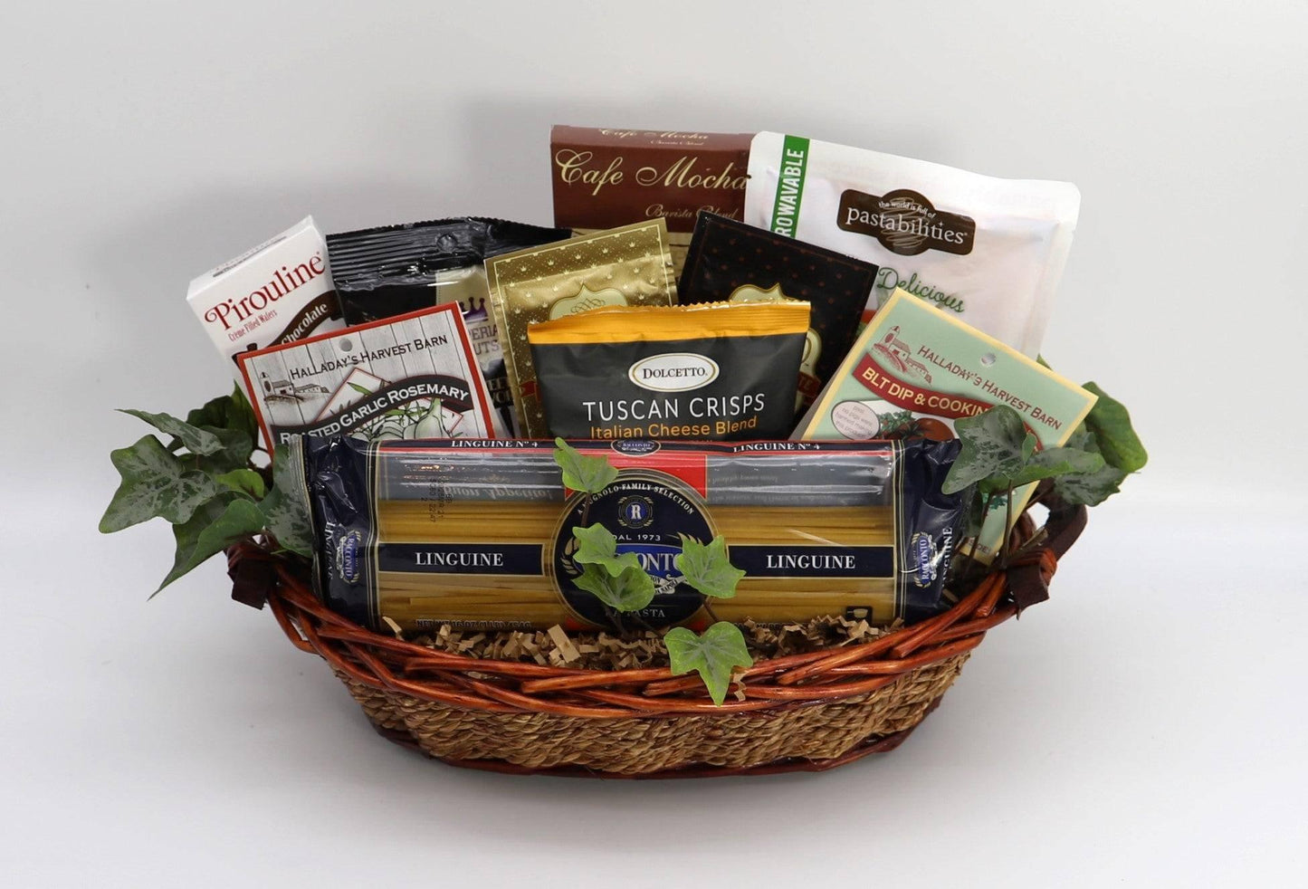 Italian gourmet gift basket in wicker basket with pasta, dips, chips, and chocolates