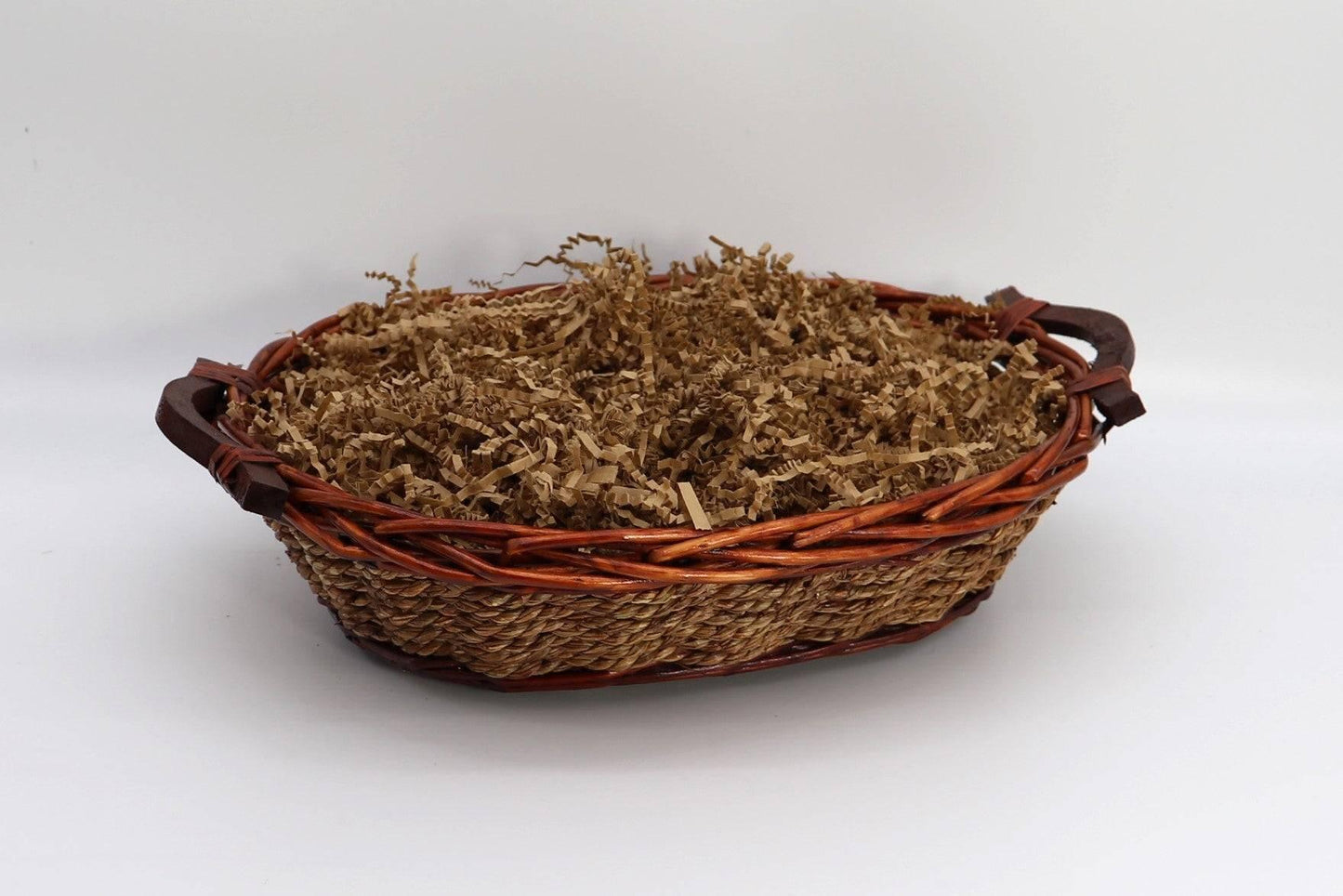Wicker gift basket filled with brown shredded paper filler