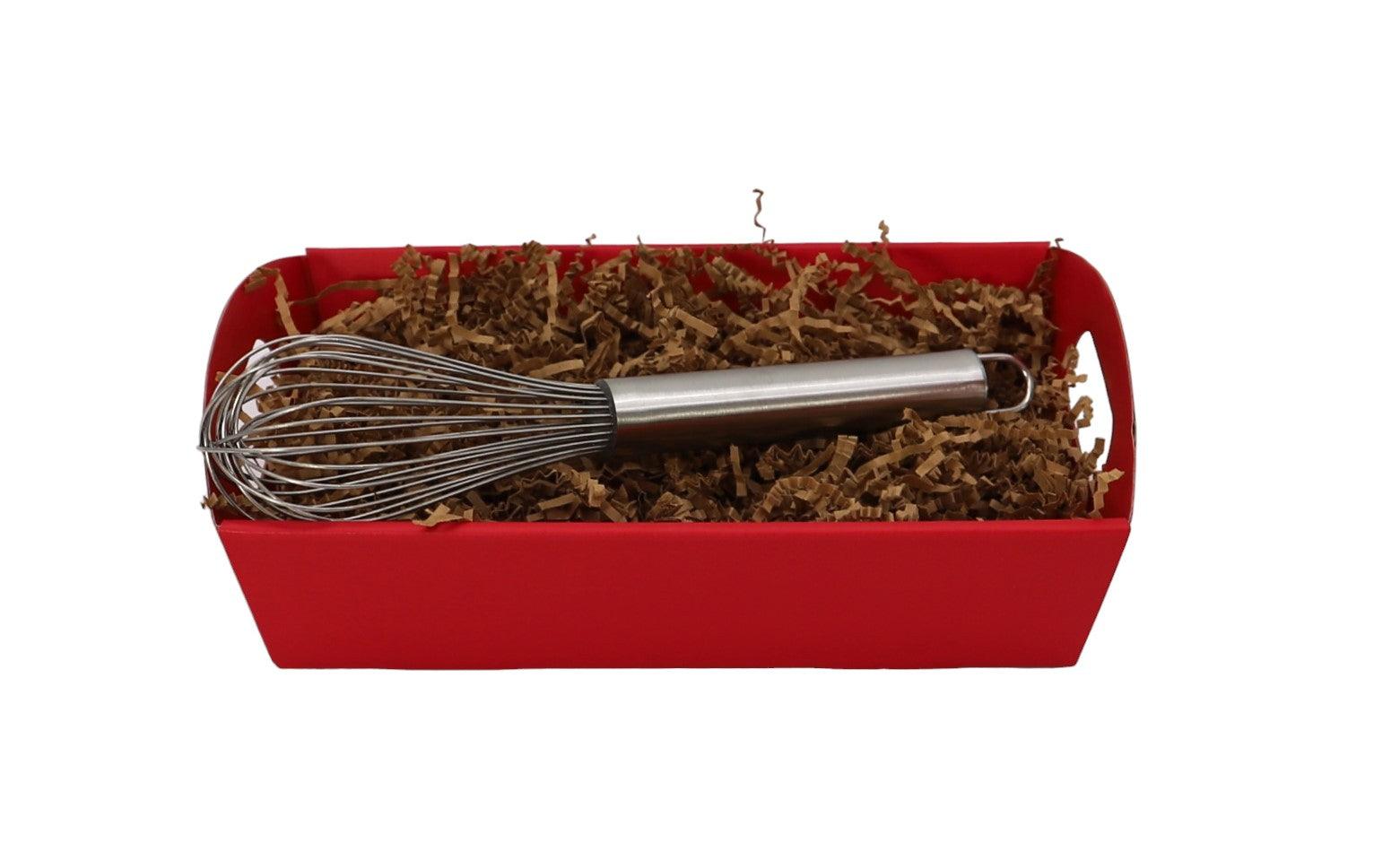 Red gift tray with metal whisk resting on brown filler