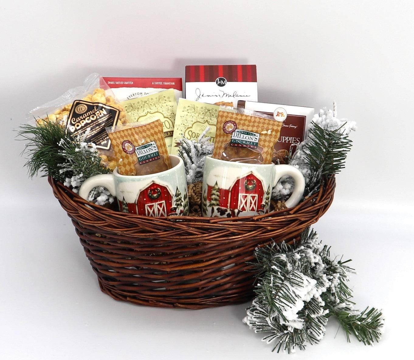 Wicker gift basket with two barn mugs, hot cocoa packets, popcorn, and pine with faux snow