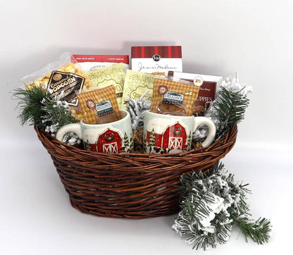 Wicker gift basket with two barn mugs, hot cocoa packets, popcorn, and pine with faux snow