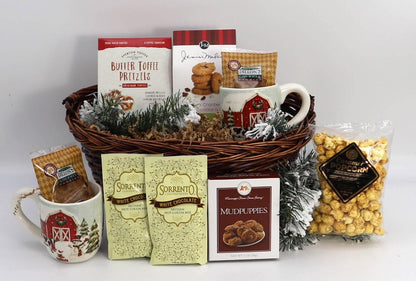 Wicker gift basket with barn mugs, hot cocoa, popcorn, candy, and faux pine with snow