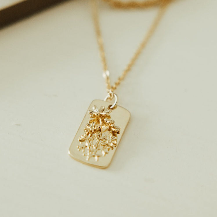Close-up of a rectangular pendant with raised floral detailing