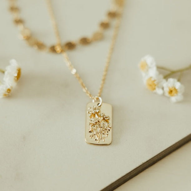 Gold-tone necklace with a rectangular floral relief pendant