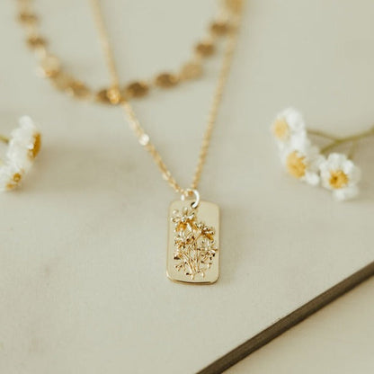Gold-tone necklace with a rectangular floral relief pendant