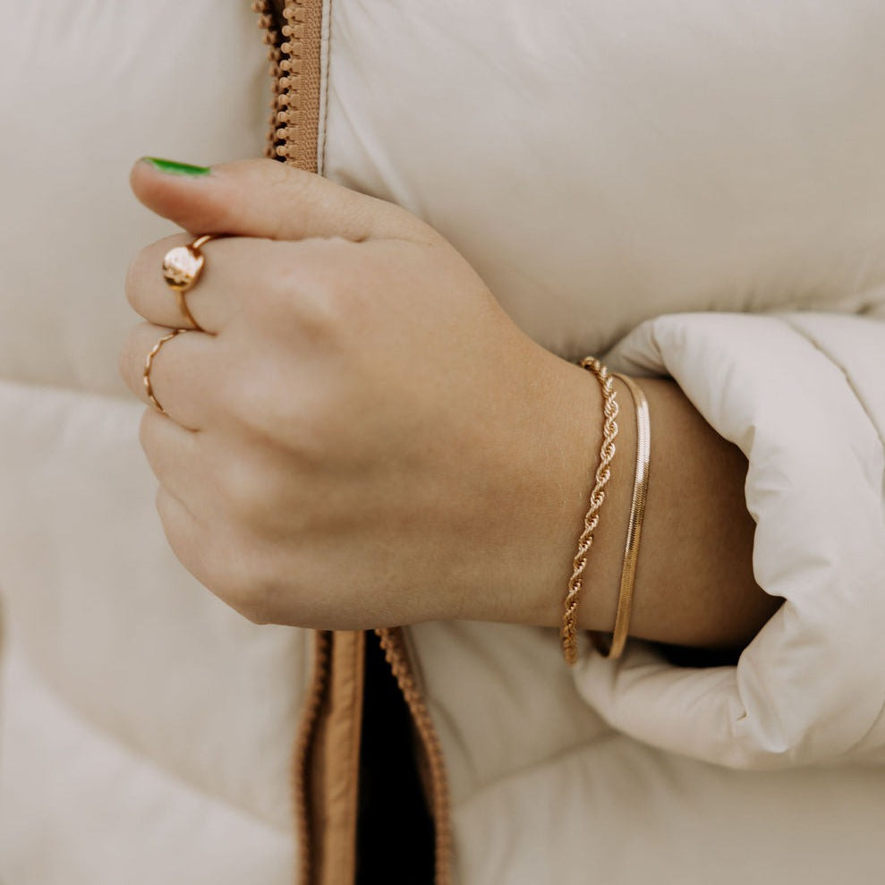 Naomi gold filled rope bracelet worn beside a slim gold bangle