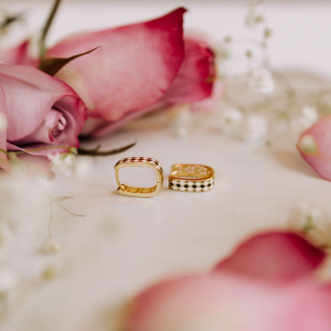 Gold reversible hoop earrings showing their patterned and plain sides