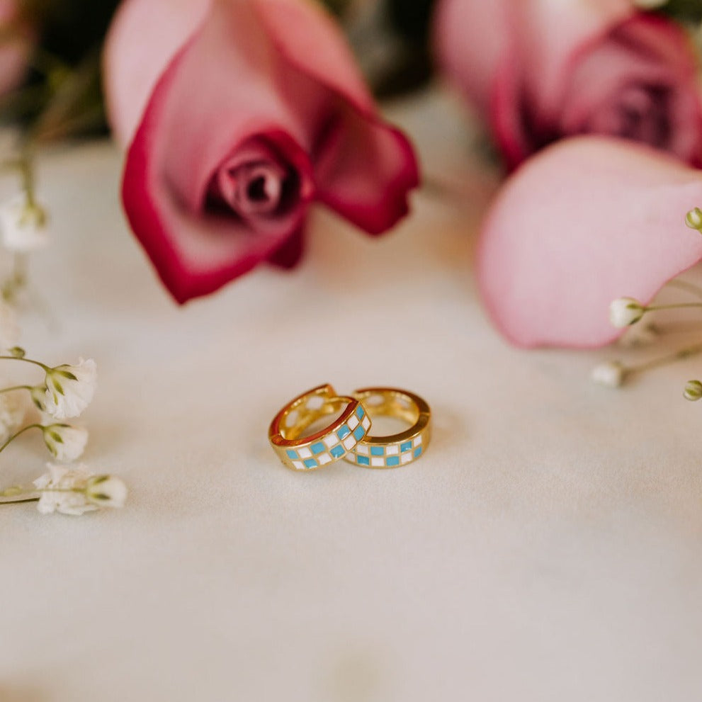 Pair of gold-tone hoops with blue and white checkerboard enamel