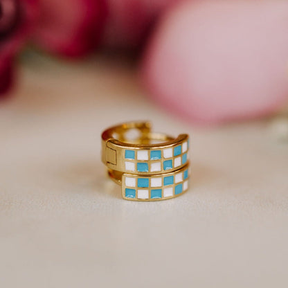 Gold-tone checkered hoop earrings with blue and white enamel squares
