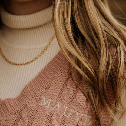 Gold-filled rope necklace worn over a cream ribbed turtleneck.