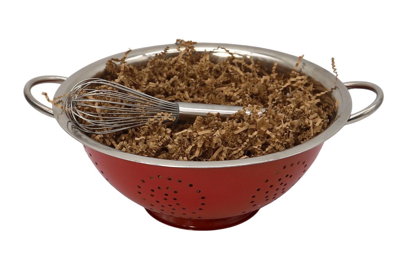 Red colander with handles filled with shredded brown herb mixture