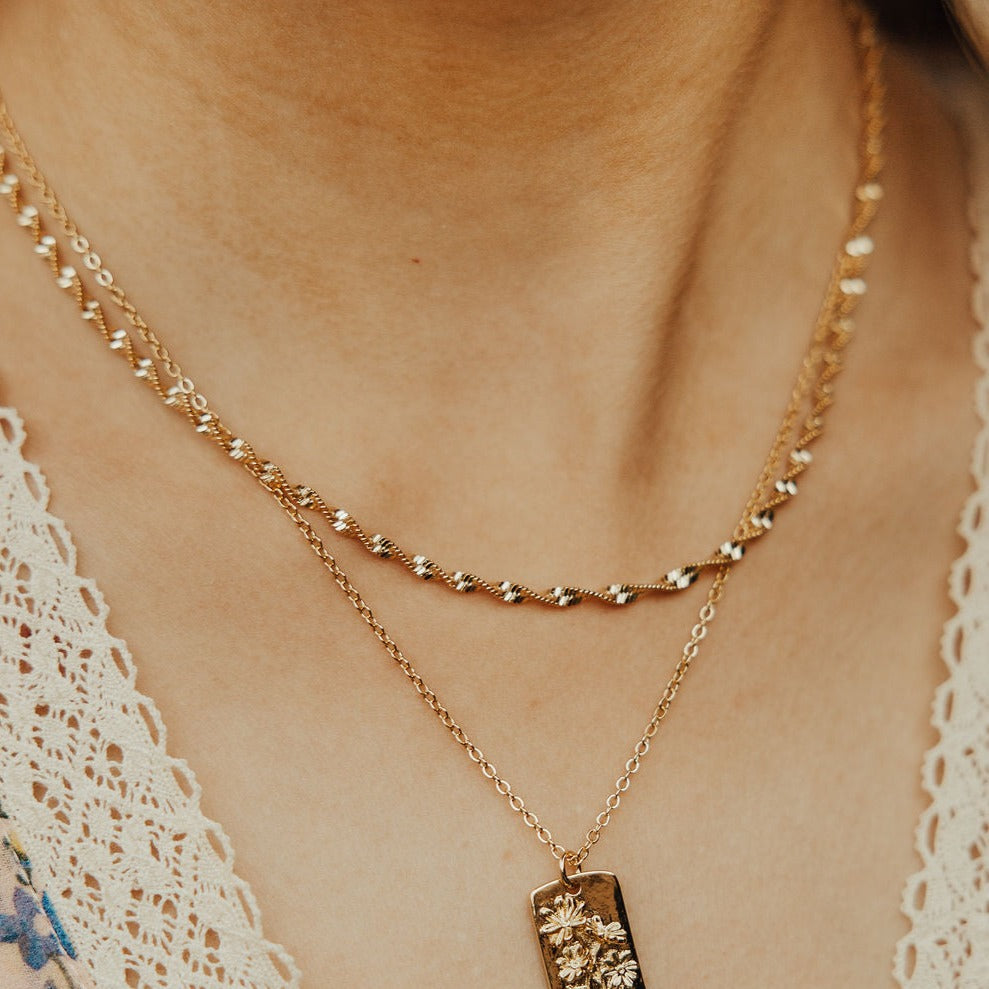 Gold-filled twist necklace worn as a layered chain.