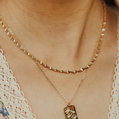 Gold-filled twist necklace worn as a layered chain.