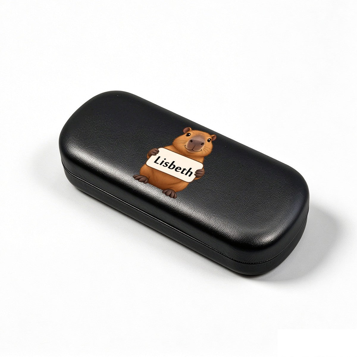 Black eyeglasses case, angled view, with capybara and name tag "Lisbeth"