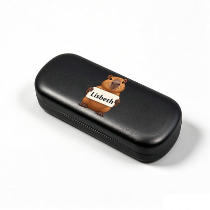 Black eyeglasses case, angled view, with capybara and name tag "Lisbeth"