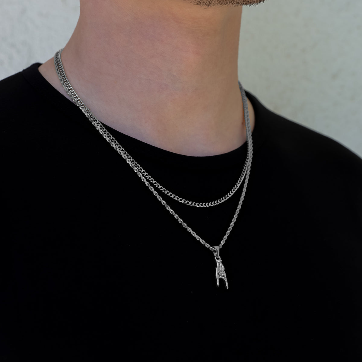 Silver pendant necklace set with horn-hand charm and layered chain
