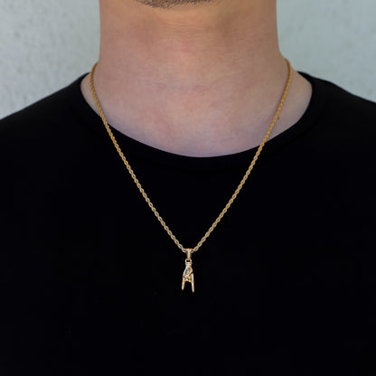 Gold pendant necklace set with horn-hand charm on layered chain