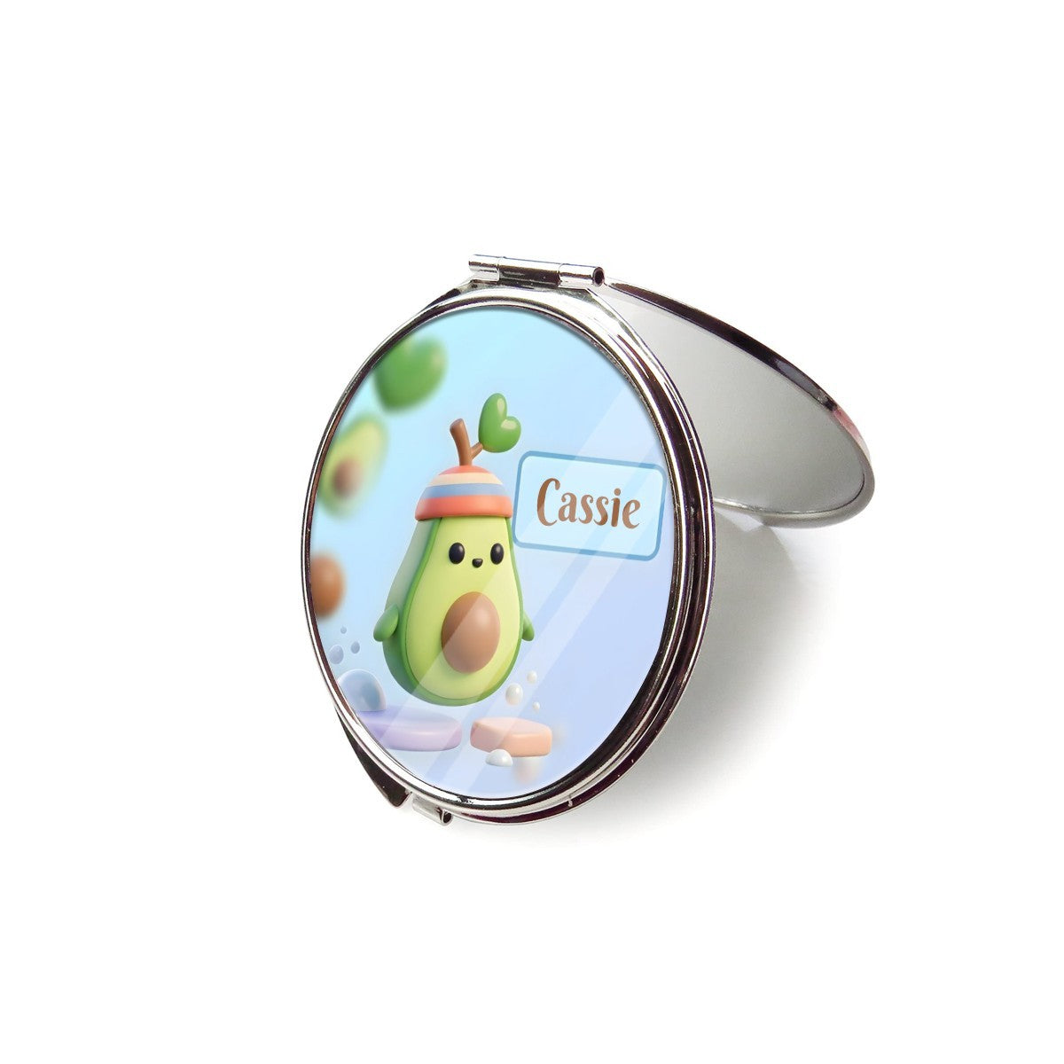 Open silver compact mirror with avocado character artwork and Cassie name on the lid