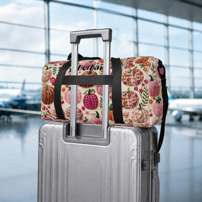Fruit-pattern duffel bag with “Bethany” patch on top, strapped to a suitcase handle