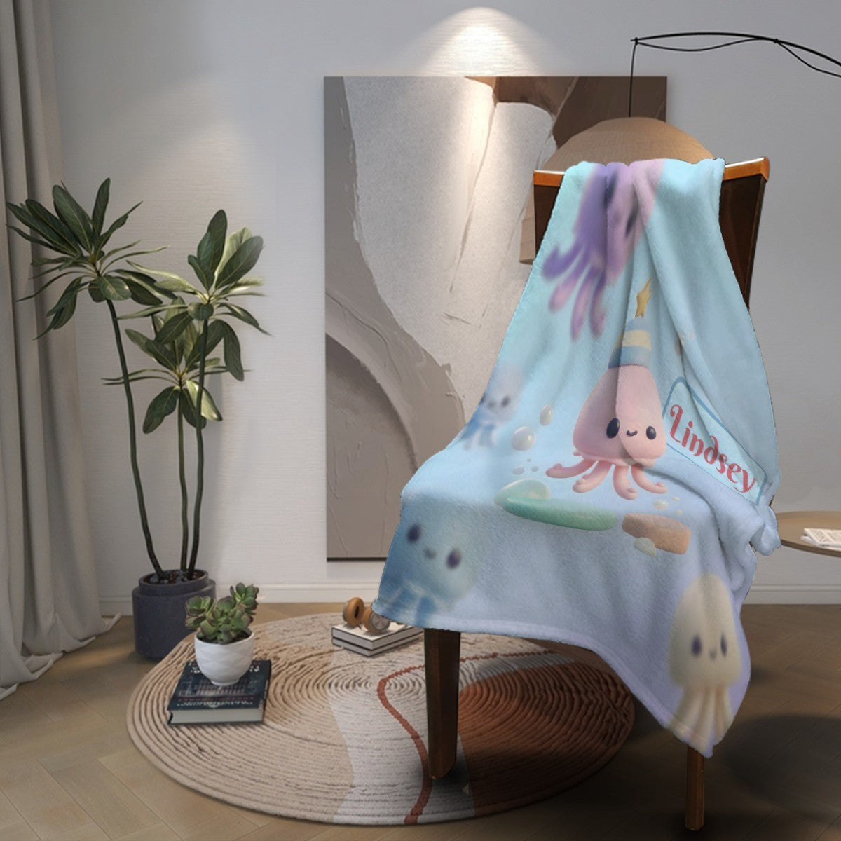 Octopus-themed light blue blanket draped over chair with octopus and Lindsey logo-style print