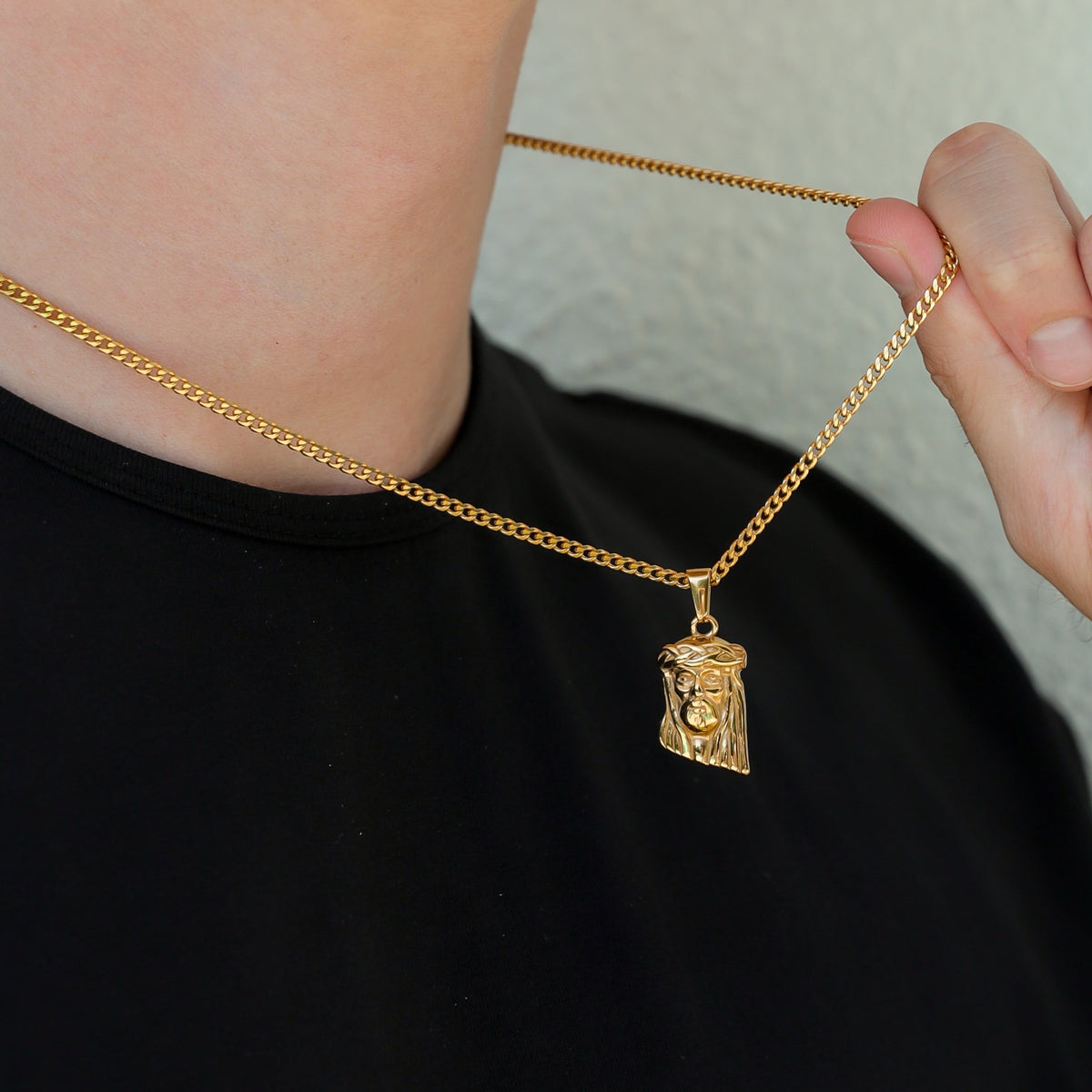 Gold Jesus pendant on linked chain necklace, close-up view