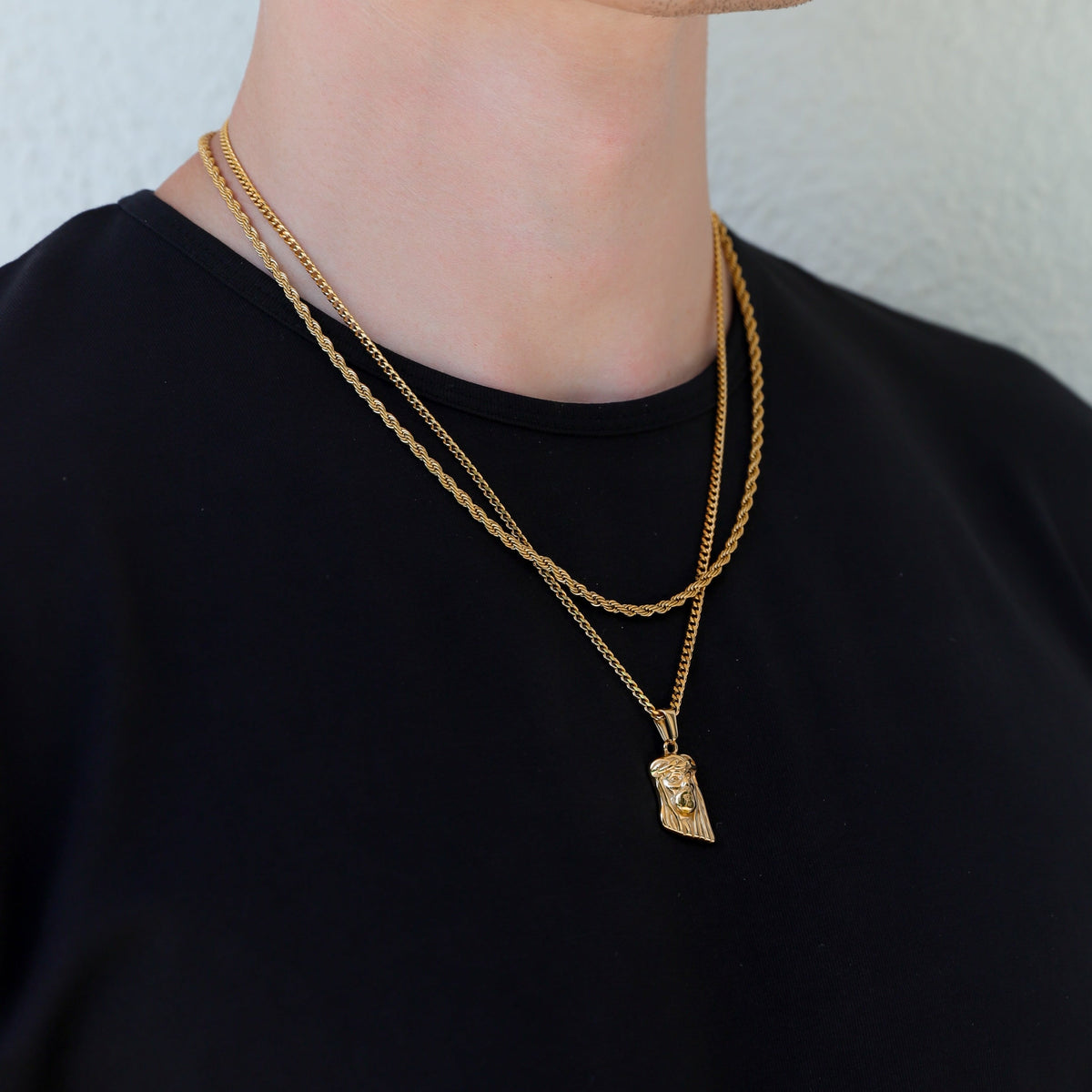 Gold Jesus pendant necklace with layered chain look on neck