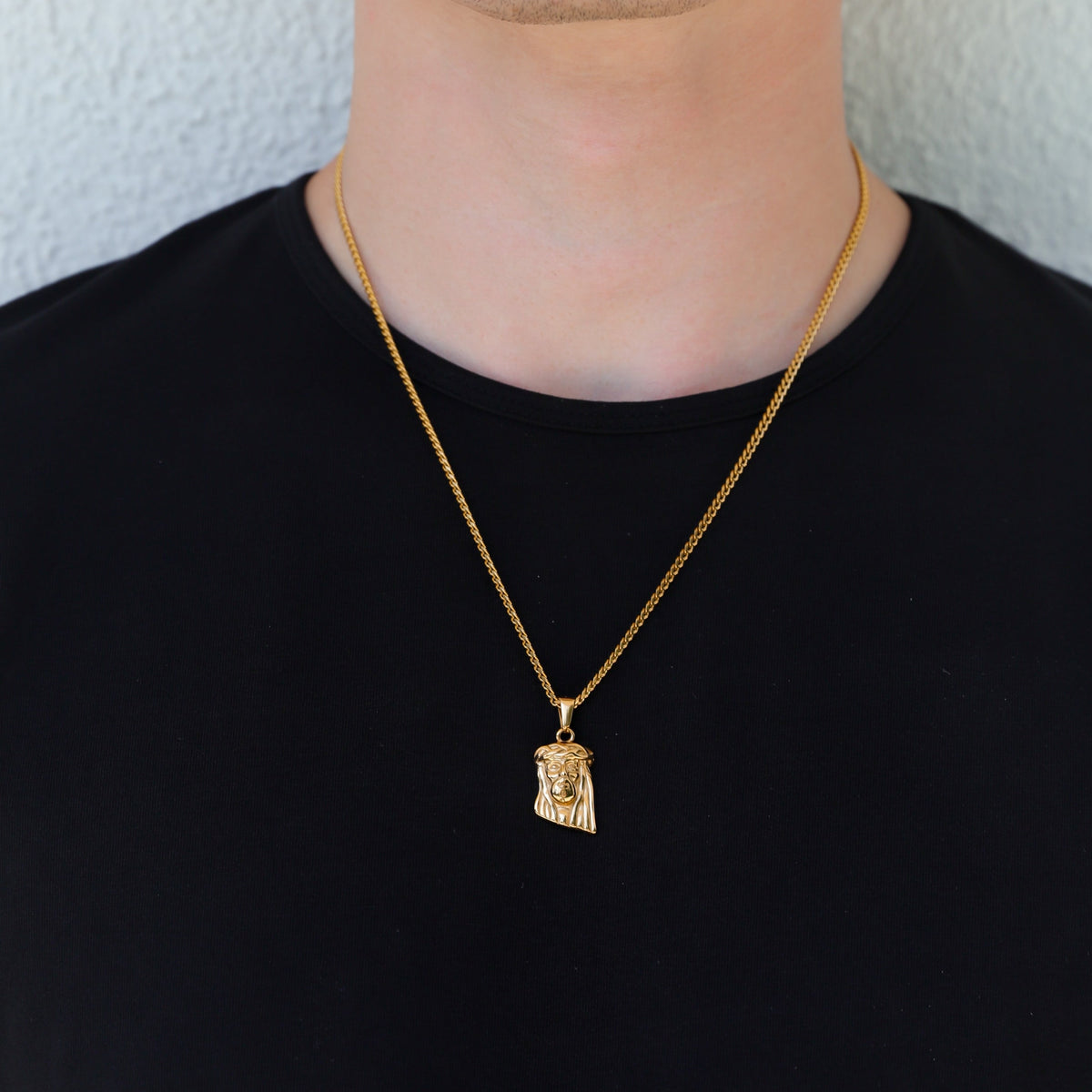 Gold Jesus charm pendant necklace worn with single chain