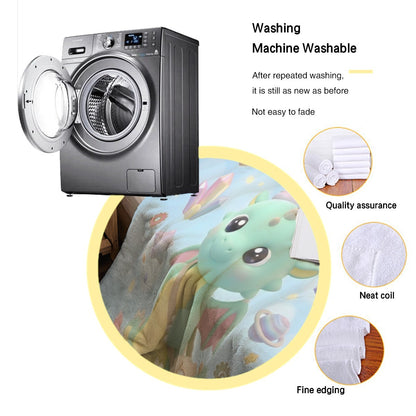 Light blue blanket with green dragon and Oliver cloud print, folded beside dryer