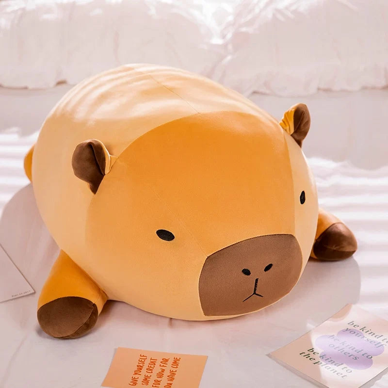 Orange capybara plush pillow with brown face and small rounded ears