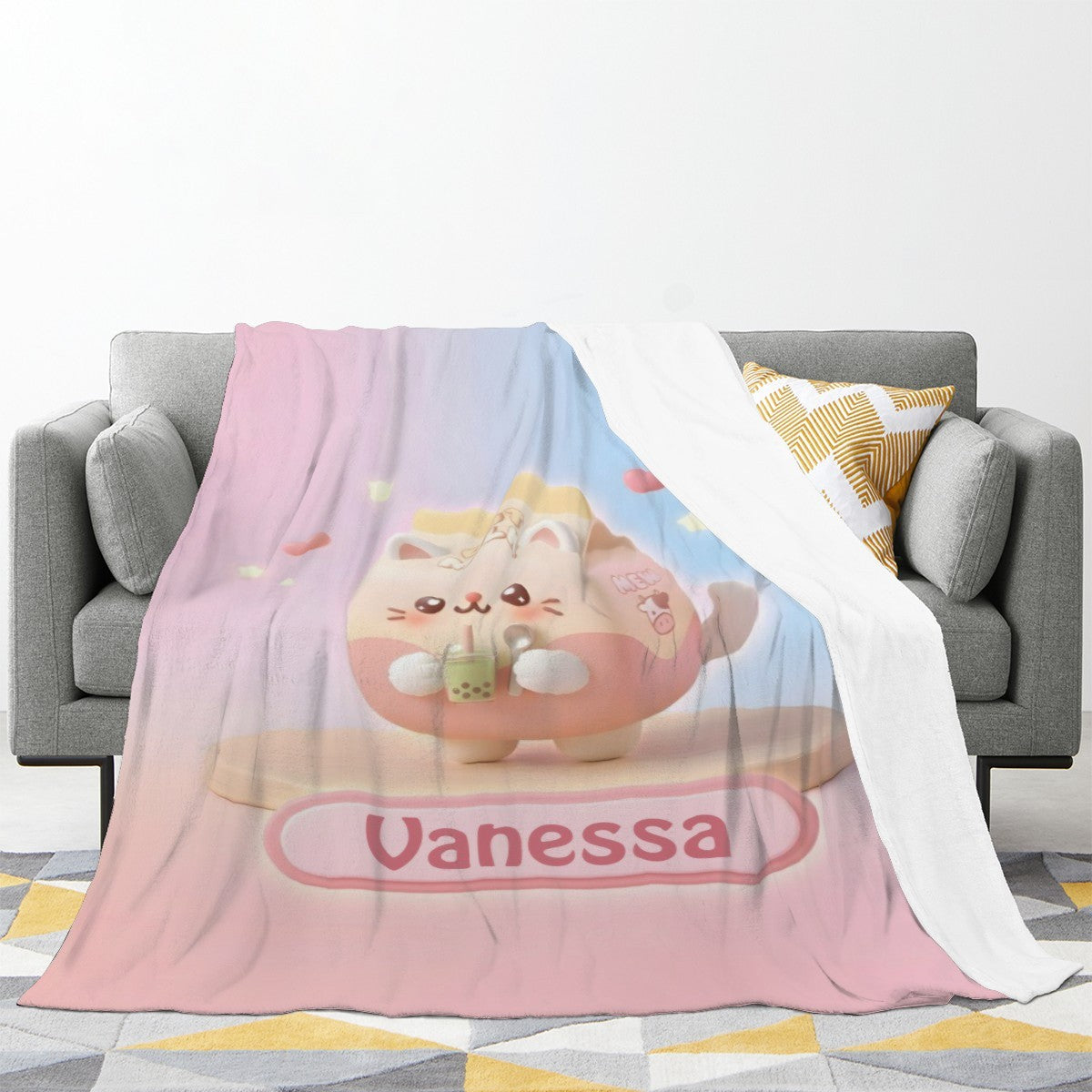 Pastel bunny blanket with pink-and-blue panels and “Vanessa” title, draped over sofa