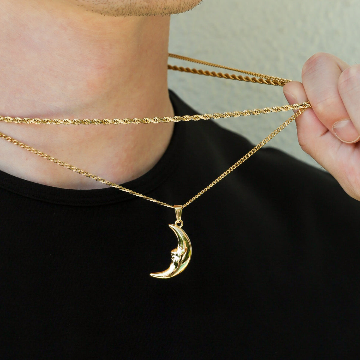 Gold crescent moon pendant necklace with layered chains and clasp detail