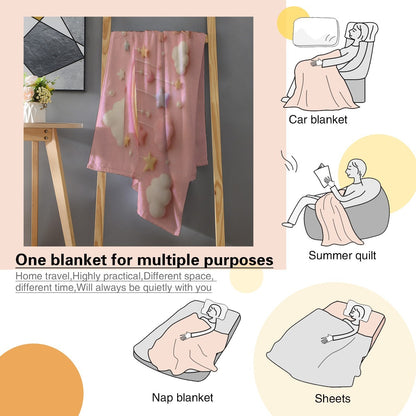 Pink blanket with unicorn and rainbow print and soft fleece texture