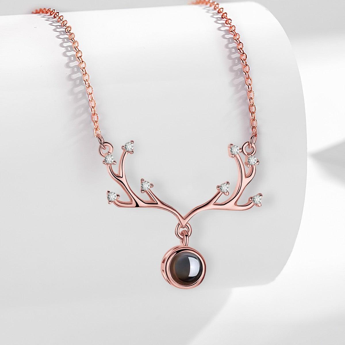 Rose gold antler pendant necklace with round projection locket and small crystal stones