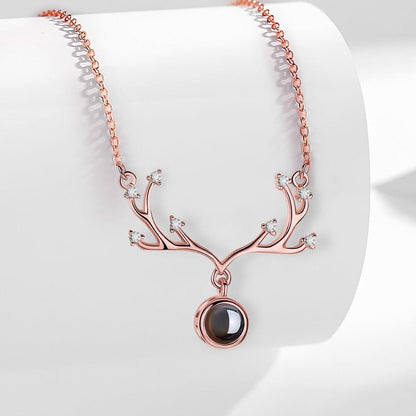 Rose gold antler pendant necklace with round projection locket and small crystal stones