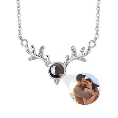 Silver-tone antler projection necklace with round photo locket and crystal antler accents