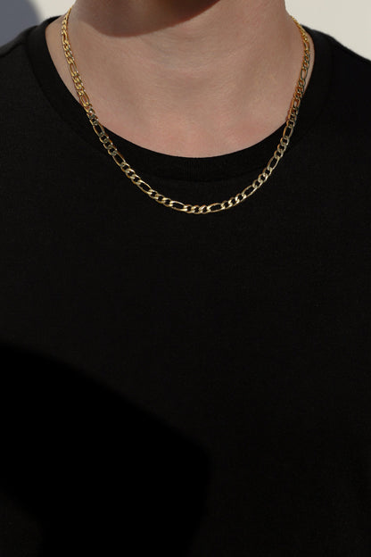 Layered gold-tone Figaro chain necklaces with oval links at collar