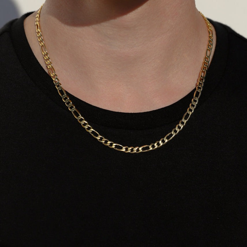 Gold-tone Figaro chain necklace on neck, oval links