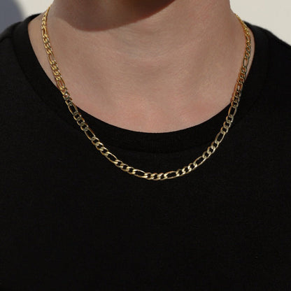 Gold-tone Figaro chain necklace on neck, oval links