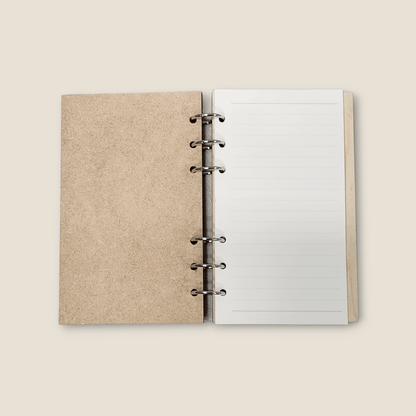 Wood refillable notebook open with blank lined pages and metal binder rings